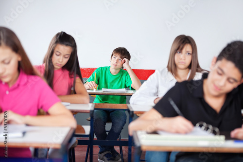 Thoughtful Schoolboy Studying In Classroom