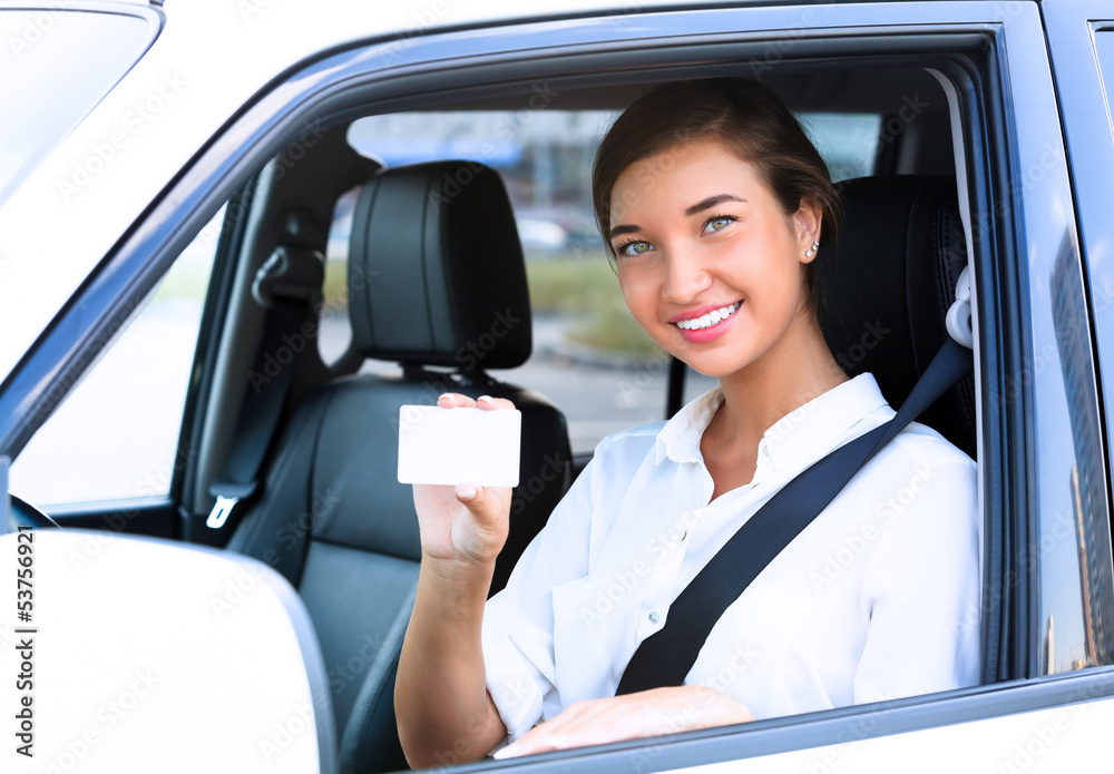 girl in a car showing an empty white card for your message