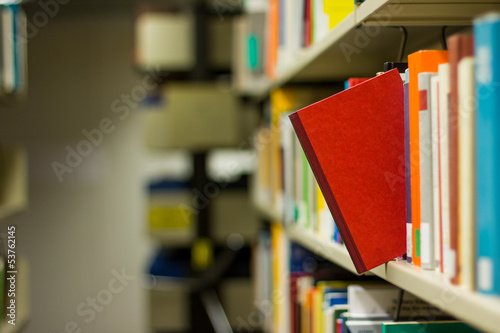 red book popping out a bookshelf photo