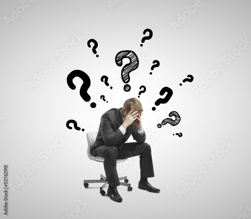 sad businessman sitting on chair with many questions