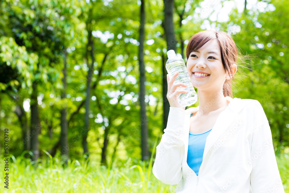 young asian woman with drinking water in the park young asian woman with drinking water in the park