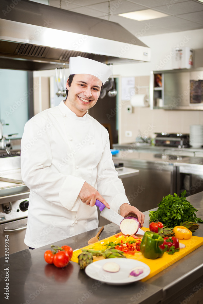 Friendly chef preparing vegetables in his kitchen Friendly chef preparing vegetables in his kitchen