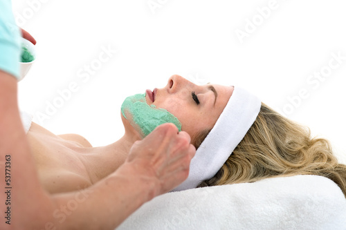 Beautician applying facial mask on beautiful woman.