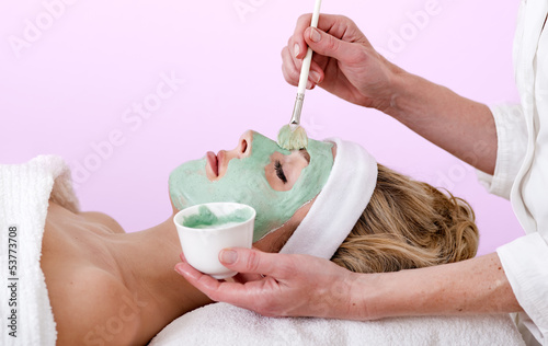 Beautician applying a thalasso face mask. photo