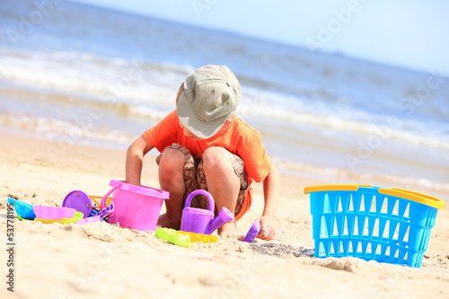 boy playing toys on beach