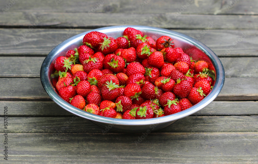 Silver bowl of strawberries on wooden table. Selective focus. Silver bowl of strawberries on wooden table. Selective focus.
