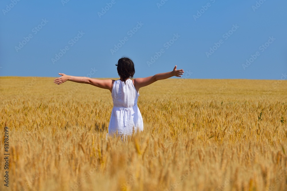 young woman in wheat field at summer
