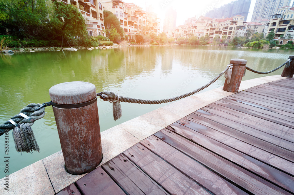 Naklejka premium platform beside lake with sunset in park