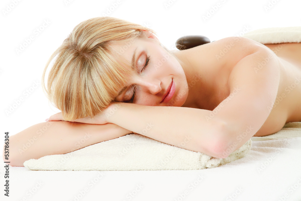 Relaxed young woman getting hot stone message at spa salon Relaxed young woman getting hot stone message at spa salon