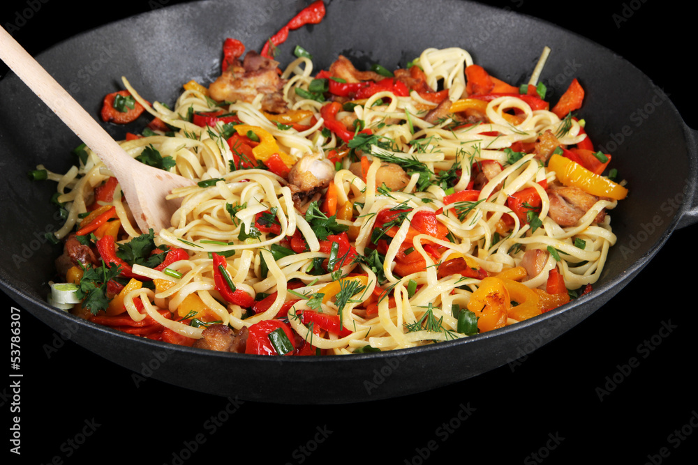 Noodles with vegetables on wok isolated on black Noodles with vegetables on wok isolated on black