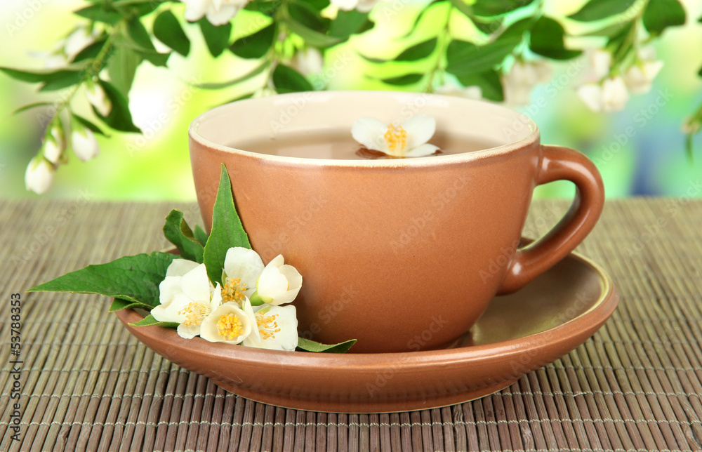 Cup of tea with jasmine, on bamboo mat, on bright background Cup of tea with jasmine, on bamboo mat, on bright background