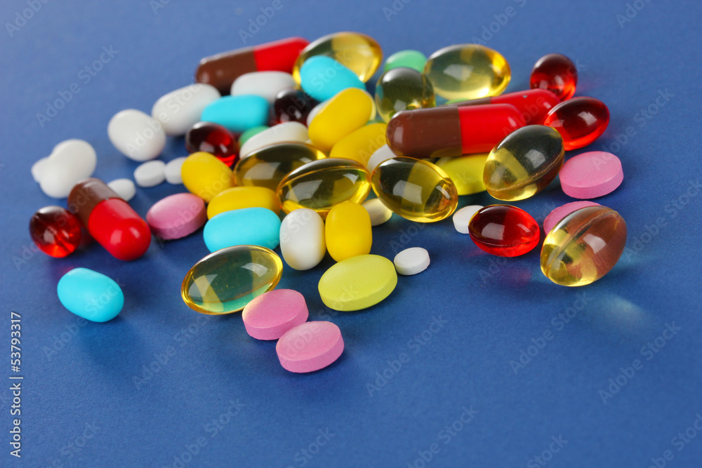Assortment of pills, tablets and capsules on blue background Assortment of pills, tablets and capsules on blue background