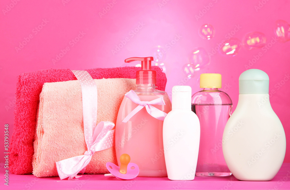 Baby cosmetics and towels on pink background Baby cosmetics and towels on pink background
