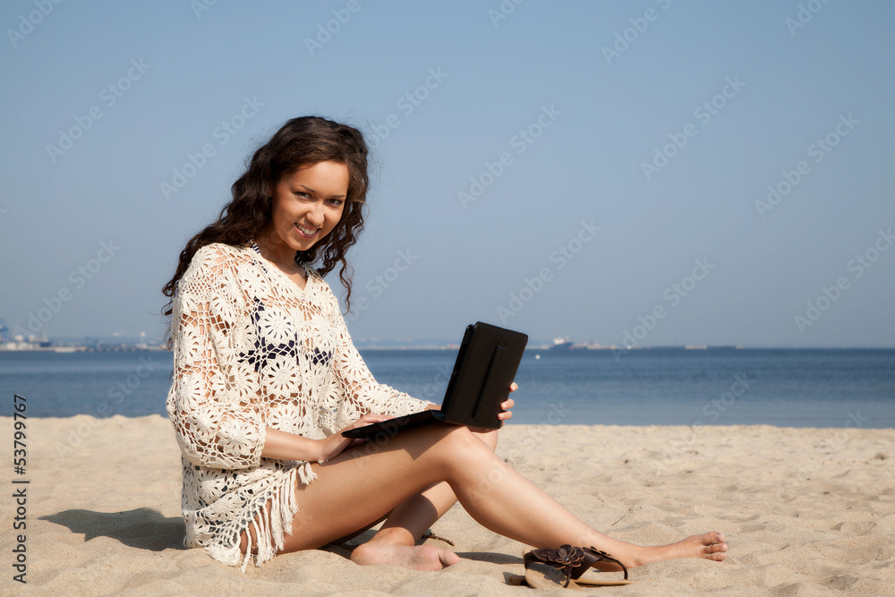 Beautiful girl working on the tablet at the beach Beautiful girl working on the tablet at the beach