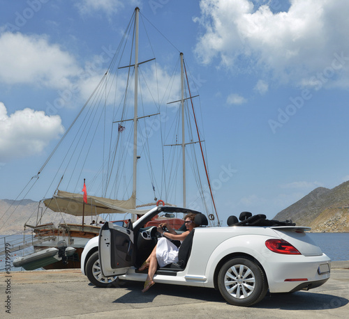 A woman in a white convertible