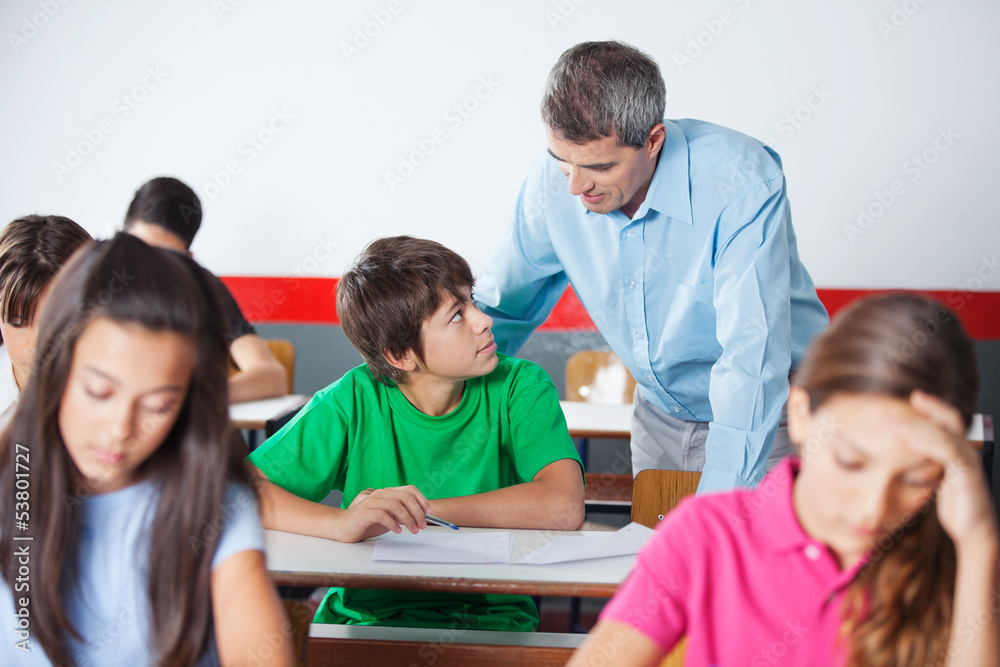Schoolboy And Teacher Looking At Each Other During Examination Schoolboy And Teacher Looking At Each Other During Examination