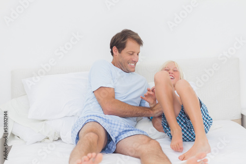 Father tickling son photo