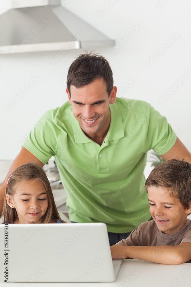 Man and his children using a laptop together