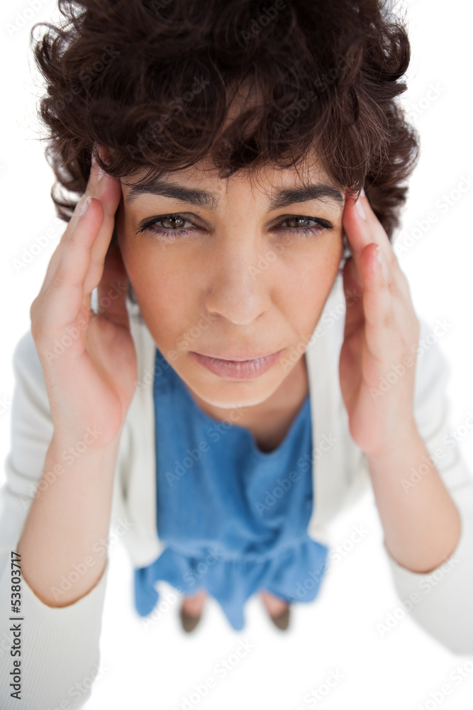 Overhead of woman with a headache touching her temples Overhead of woman with a headache touching her temples
