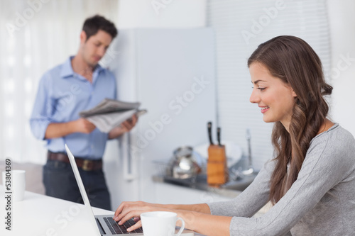 Attractive woman using her laptop in the kitchen