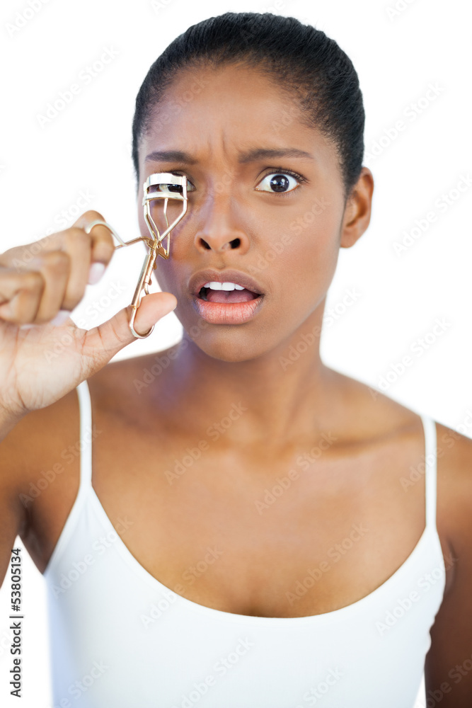 Shocked woman using curler for her eyelash Shocked woman using curler for her eyelash