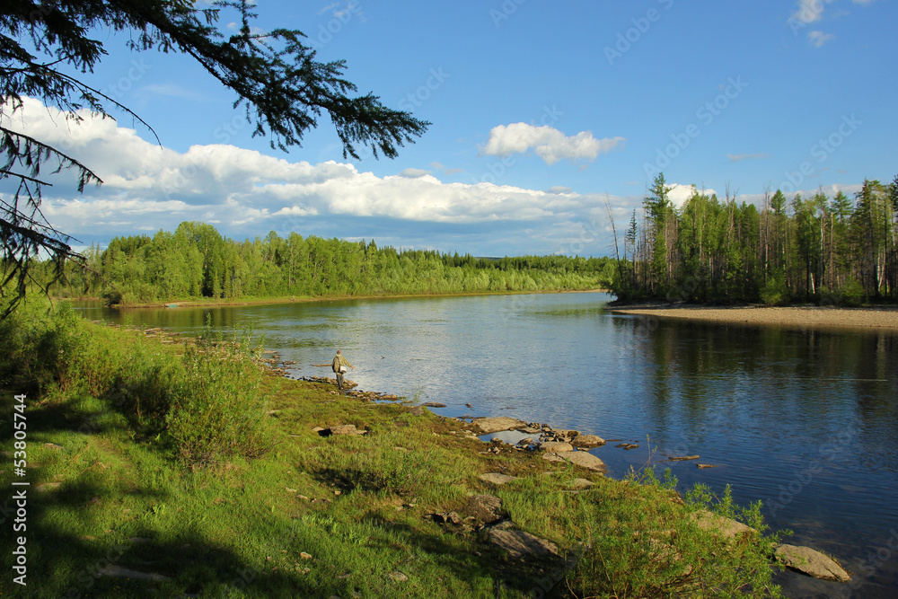 Fototapeta premium A fisherman on the river Ungru in South Yakutia