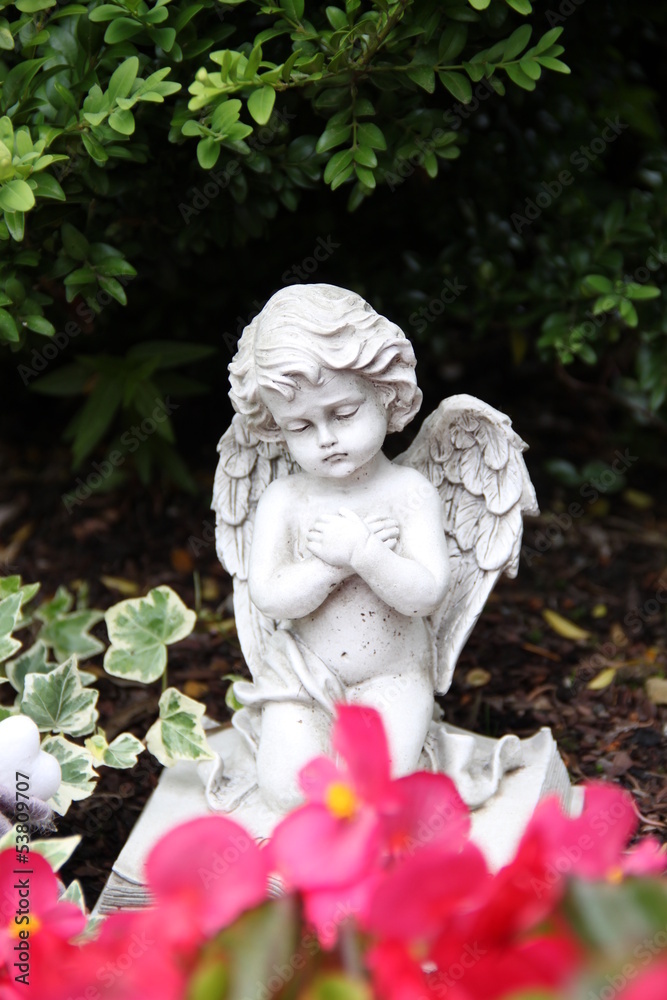 Trauriger kleiner Engel auf einem Grab