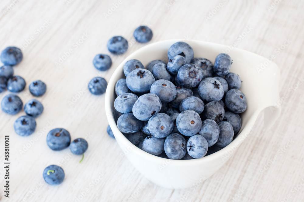 White bowl cup with fresh ripe blueberries White bowl cup with fresh ripe blueberries