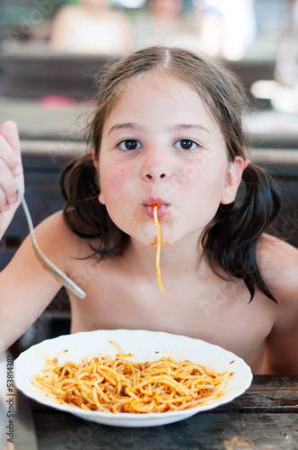 Young girl eating pasta
