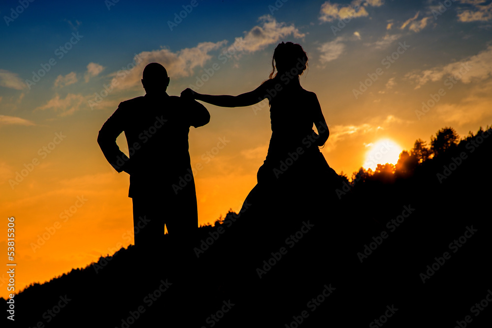 Couple standing with amazing sunset in backdrop