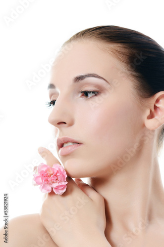 The beautiful woman holds a flower of a carnation at the face