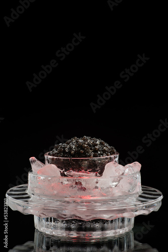 Black caviar on a black isolated and blank