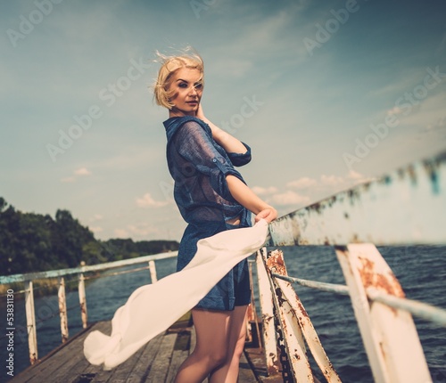 Stylish beautiful woman on an old pier