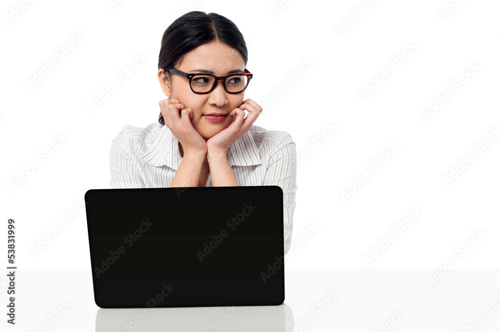 Businesswoman at her work desk, looking away Businesswoman at her work desk, looking away