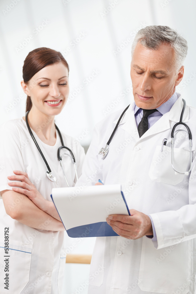 Asking for advise. Confident hospital colleagues writing in a no Asking for advise. Confident hospital colleagues writing in a no