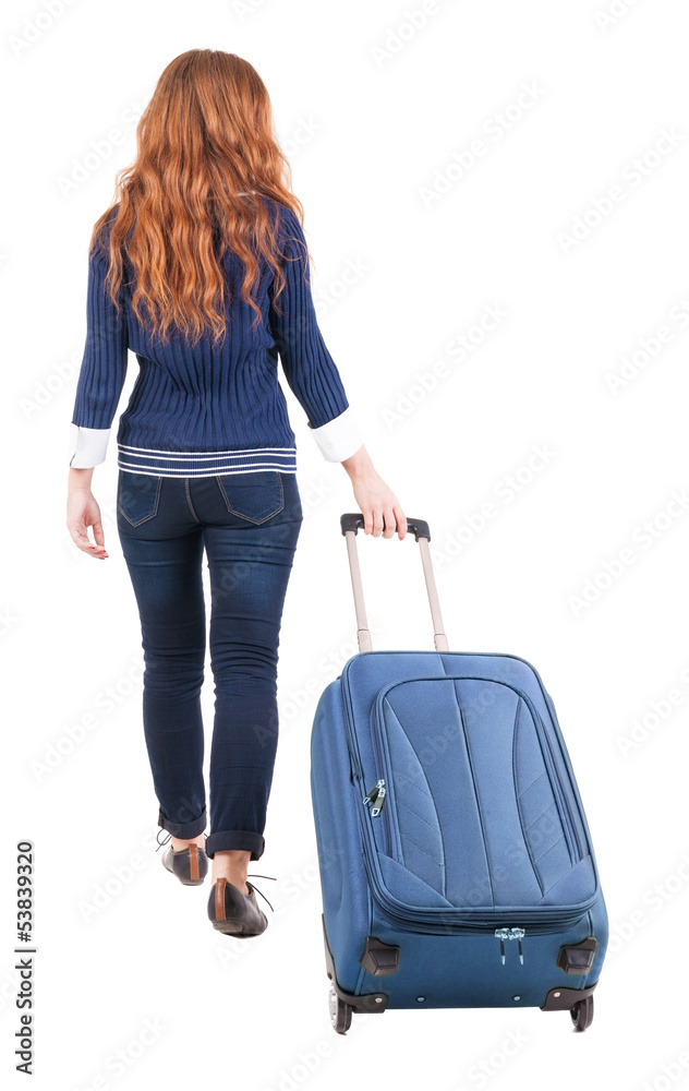 back view of walking  woman  with suitcase