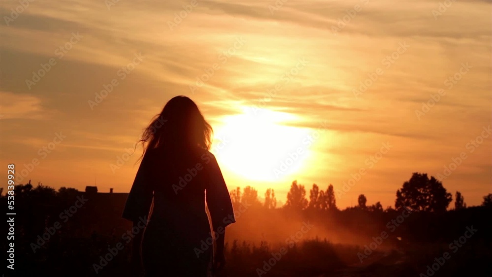 silhouette of a girl walking into the sunset silhouette of a girl walking into the sunset