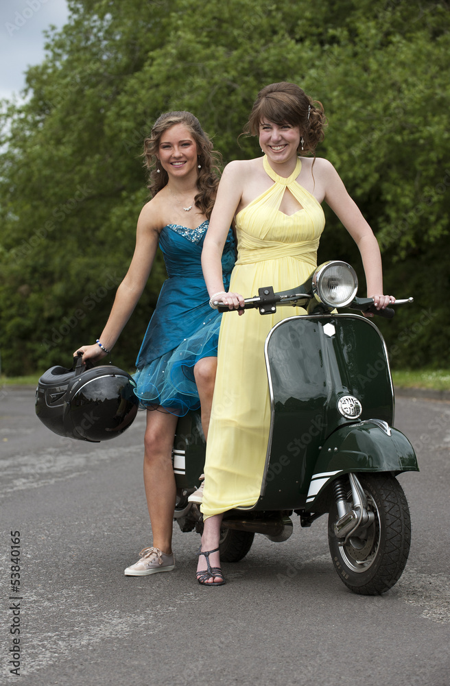 Girls in party dresses ride a motor scooter Stock Photo | Adobe Stock