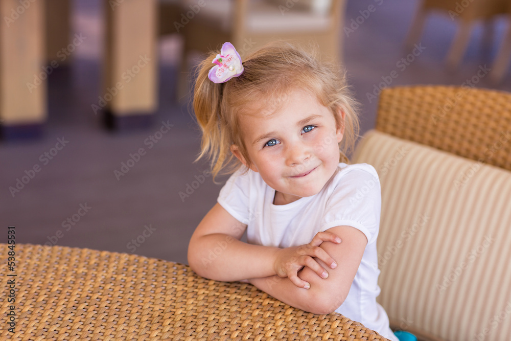 Fototapeta premium Cute little child at the table in a restaurant