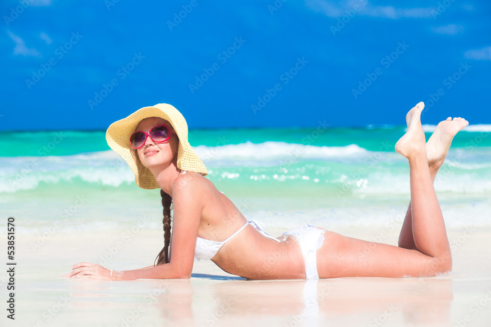 Beautiful woman in white bikini on the beach. Travel concept