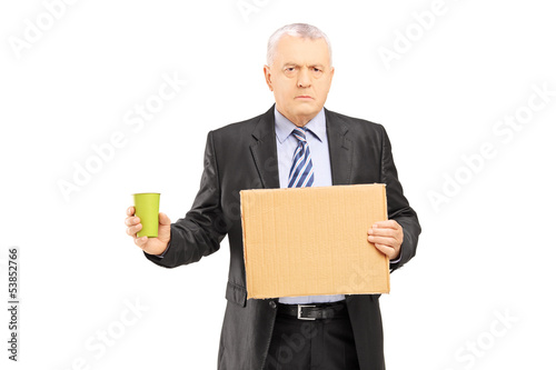 Bankrupted mature businessman holding a piece of cardboard and c © Ljupco Smokovski