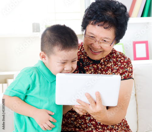 Asian senior woman and grandson using tablet computer