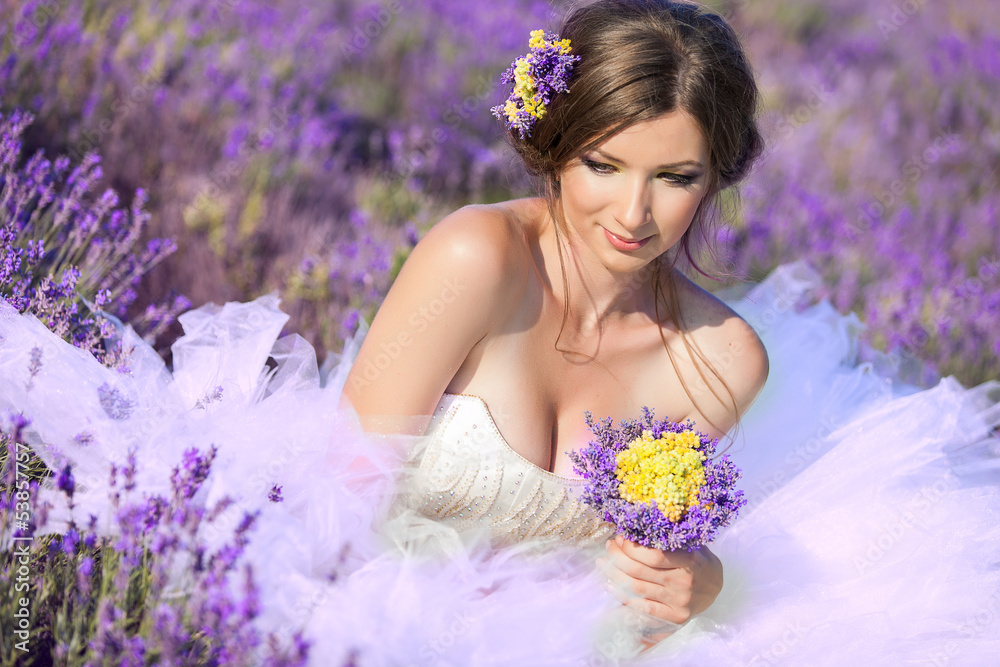 Fototapeta premium Beautiful bride posing at field of lavender