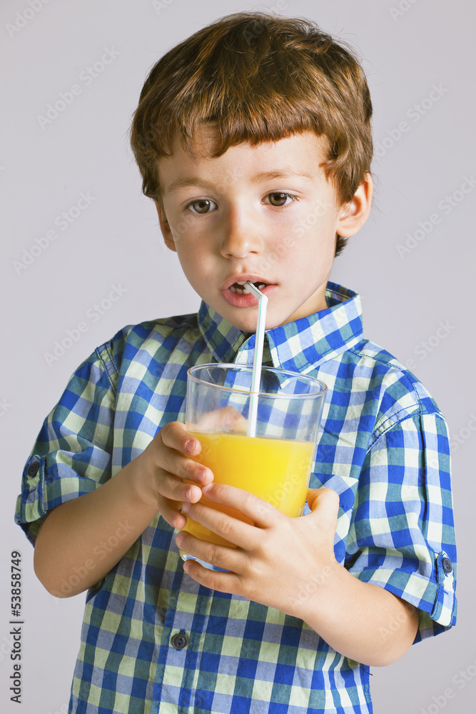 Child with plaid shirt drinking a fresh orange juice. Child with plaid shirt drinking a fresh orange juice.