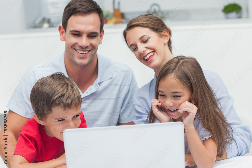 Cheerful parents and children using a laptop Cheerful parents and children using a laptop