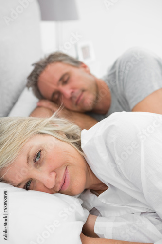 Woman awake as her partner is sleeping in bed