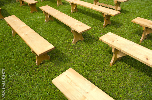 new wooden benches on grass in park