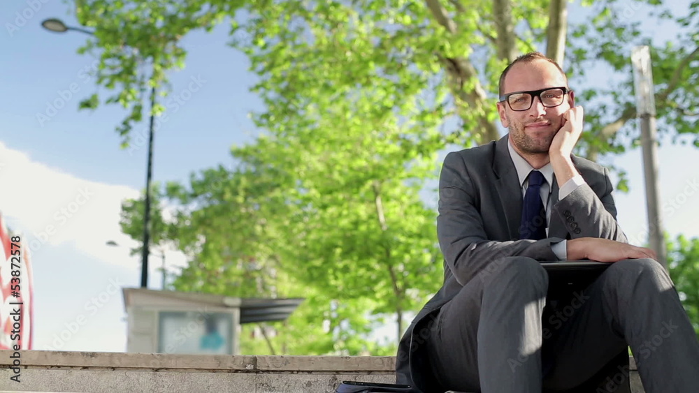 Portrait of young happy businessman in the city