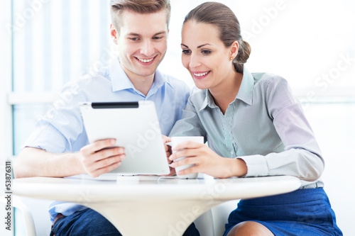 Business couple looking at digital tablet