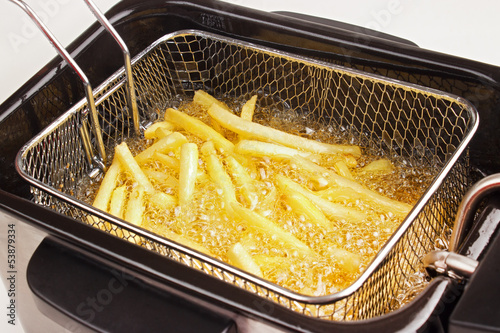 French fries in hot fat in a deep fryer